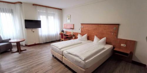 a hotel room with a bed and a television at Zum Winzermännle in Würzburg