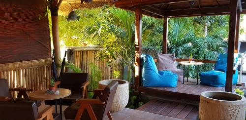 a porch with blue pillows and chairs and tables at Ombak Resort at Ekas , a luxury surf and kite destination, Close to Inside Ekas beach in Ekas