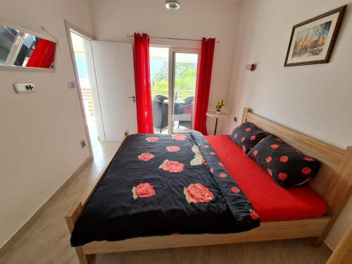 Apartment Darija في كوتور: غرفة نوم مع سرير مع لحاف أسود وأحمر