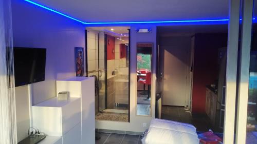 Elle comprend un salon doté d'un plafond violet et d'une télévision. dans l'établissement Le Vénusia du CAP - Clim, stationnement, ménage et linge fournis, au Cap d'Agde