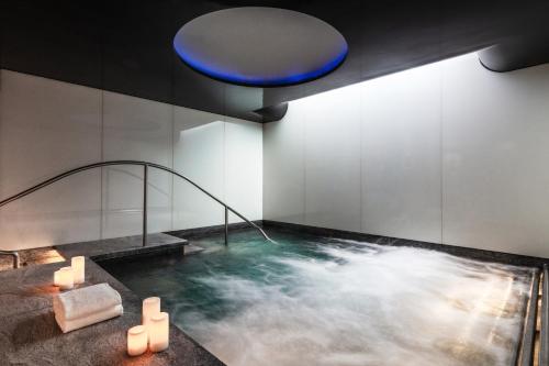 a bath room with a bath tub and a pool of water at Four Seasons Hotel London at Park Lane in London