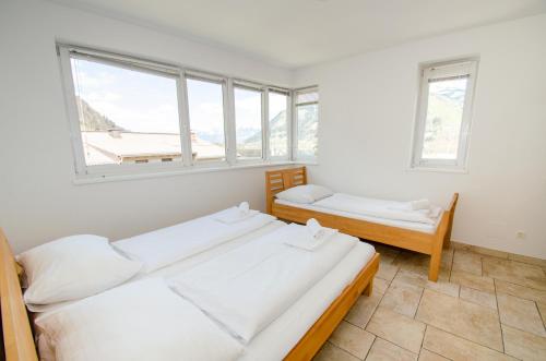 una camera da letto con due letti e due finestre di Penthouse in the heart of Zell am See a Zell am See