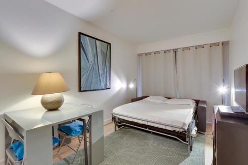 une chambre avec un lit et une table avec une lampe dans l'établissement ID 326 Batignolles/ rue Saussure - Paris XVII°, à Paris