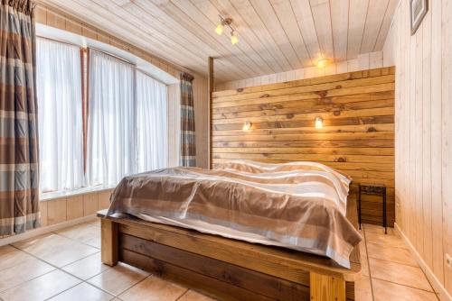 a bedroom with a bed in a room with wooden walls at Château Ferme de Laval in Sainte-Ode
