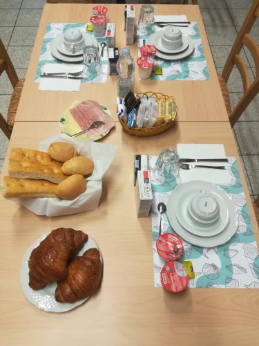 uma mesa com pratos de comida e pão em Casa per Ferie Nostra Signora Tonfano em Marina di Pietrasanta
