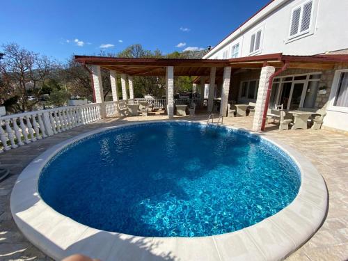 a large blue swimming pool in front of a house at Vila Punta in Šibuljina