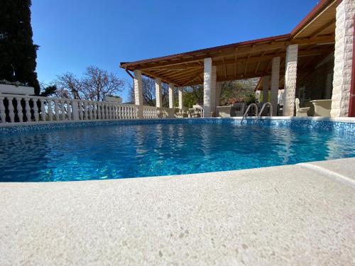 a swimming pool with a wooden fence and a swimming pool at Vila Punta in Šibuljina