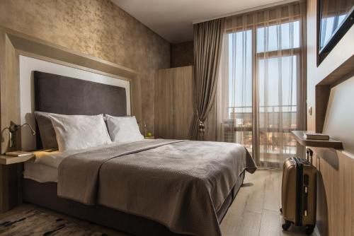 Una habitación de hotel con una cama y una ventana grande. en Boutique Apartments - Sevtopolis, en Kazanlak
