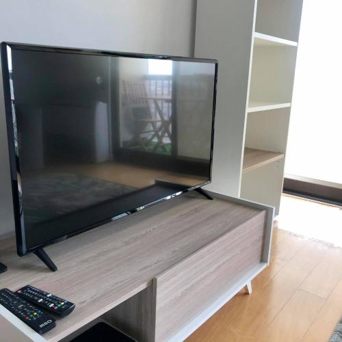 a large flat screen tv sitting on a entertainment center at Azores Avenida E Apartment T3 in Ponta Delgada
