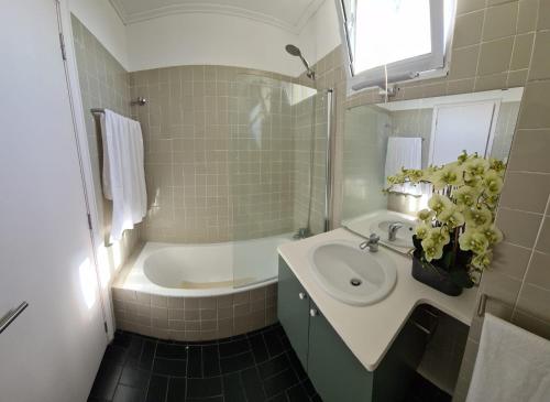 a bathroom with a sink and a bath tub at Azores Avenida E Apartment T3 in Ponta Delgada