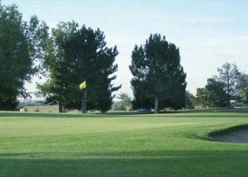 a golf course with a yellow flag on the green at Holiday Inn Express Hotel & Suites Limon I-70/Exit 359 by IHG in Limon
