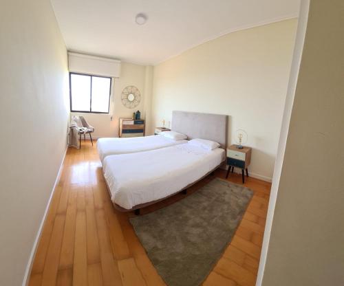 a bedroom with two beds and a window at Azores Avenida E Apartment T3 in Ponta Delgada
