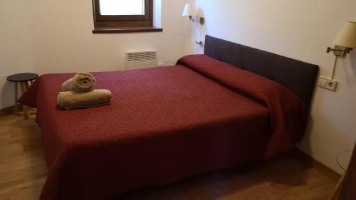 een slaapkamer met een rood bed met een knuffeldier erop bij Apartament de la Lali Roní in Roní