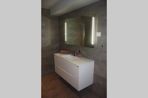 uma casa de banho com um lavatório branco e um espelho. em Meget flott leilighet i Stryn sentrum em Stryn