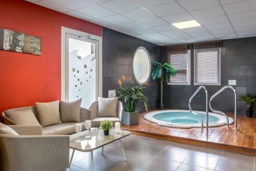 uma sala de estar com jacuzzi em Best Western Hotel Nuit De Retz Nantes Sud em Port-Saint-Père