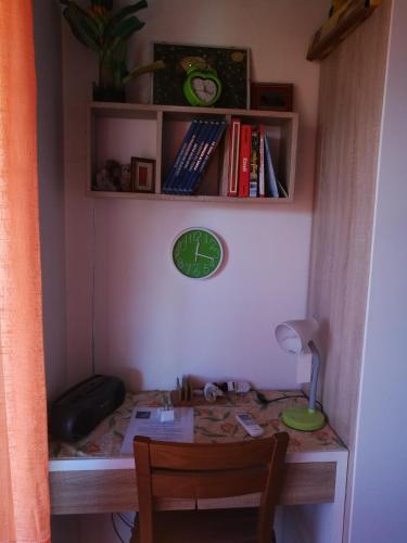 a desk with a clock on a wall with a shelf at B&B Antica Corte Lombarda in Mortara