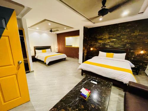 um quarto com 2 camas e uma parede de tijolos em 12th Avenue em Lahore