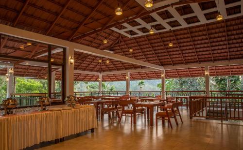 a restaurant with tables and chairs in a building at Terrace Resorts in Wayanad