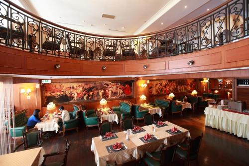 a restaurant with tables and chairs and a balcony at Grand Boss Hotel in Yilan City