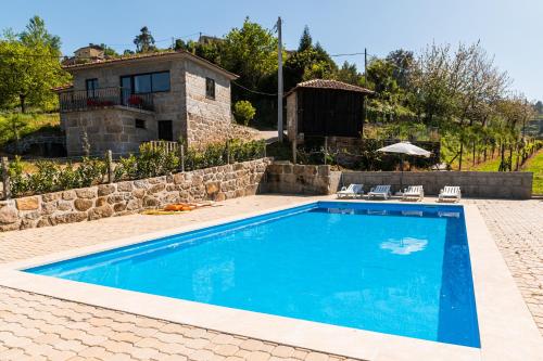 a swimming pool in front of a house at Partezins I in Castelo de Paiva