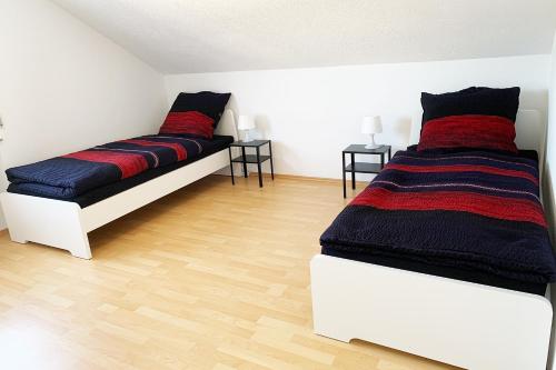 a bedroom with two beds and two tables at Ruhig gelegene Ferienwohnung mit WLAN in Olpe