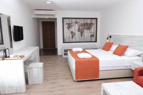 a hotel room with a bed and a tv at Club Turtas Beach - All Inclusive in Konaklı