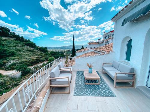a patio with chairs and a table on a balcony at Montgo Home in Jávea