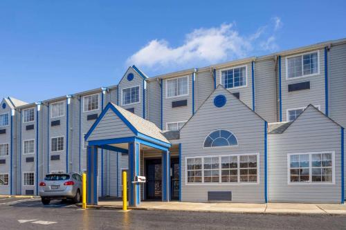a building with a car parked in front of it at Microtel Inn & Suites by Wyndham Matthews/Charlotte in Matthews
