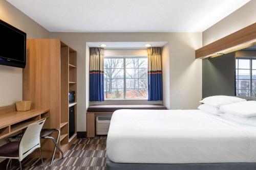 a hotel room with a large bed and a window at Microtel Inn & Suites by Wyndham Matthews/Charlotte in Matthews
