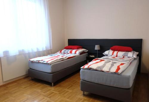 dos camas sentadas una al lado de la otra en una habitación en CAMPANELL - Das Ferienhaus im Blaufränkischland, en Deutschkreutz