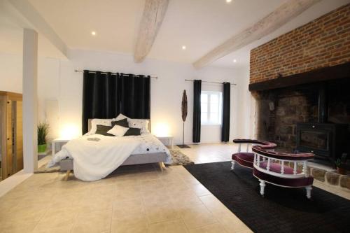 ein Schlafzimmer mit einem Bett und einem Kamin in der Unterkunft Sauna et jacuzzi - Les mille et une nuits - 2km mer in Le Bourg-Dun