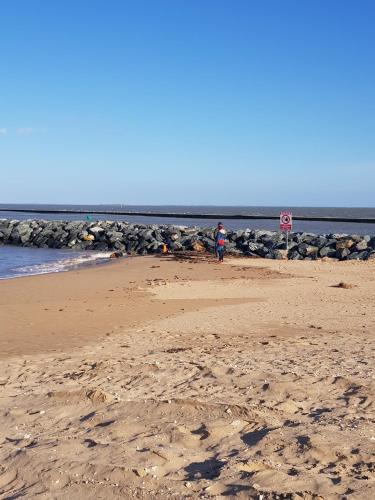 a person walking on a beach with a stop sign at ARRETEZ VOUS A OLERON in Le Château-dʼOléron