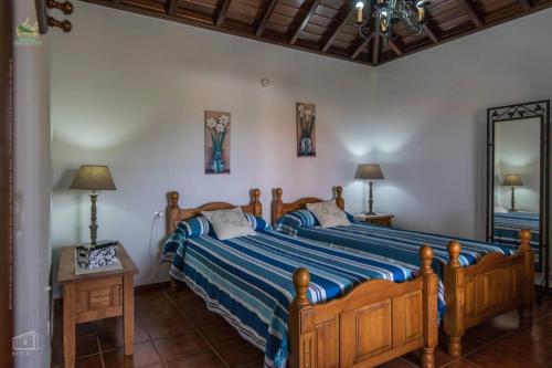1 dormitorio con 1 cama grande y espejo en CASAS COREA, en Puntagorda