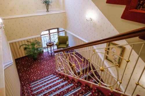 a spiral staircase with a chair and a plant at Ringhotel Schloss Tangermünde in Tangermünde