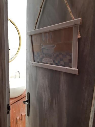 a bathroom door with a sink and a mirror at Al Alba Vivienda Vacacional VV1865AS in Illas