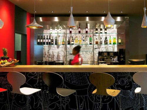 a person sitting at a bar in a restaurant at Hotel ibis Lisboa Saldanha in Lisbon