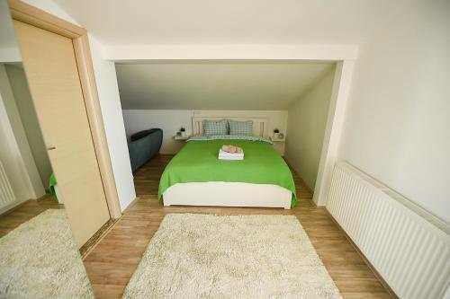 a bedroom with a green bed in a small room at The Green Apartments in Magarevo