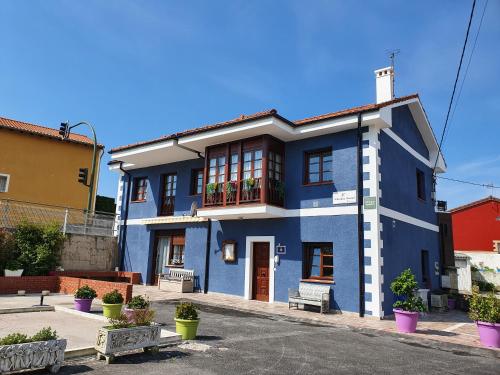 un edificio azul con balcón en una calle en Albergue Piedad, en Boó de Piélagos