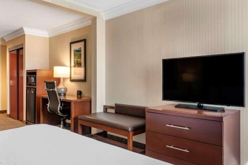 a hotel room with a bed and a flat screen tv at Comfort Suites Downtown Carlisle in Carlisle
