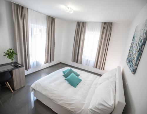 1 dormitorio con cama blanca y almohada azul en Self Service Hotel Kernhof Langstrasse en Zúrich
