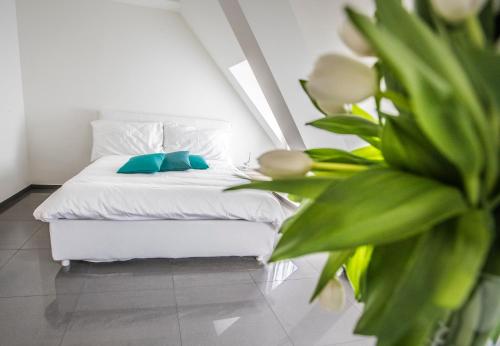 a bedroom with a white bed and a plant at Self Service Hotel Kernhof Langstrasse in Zurich