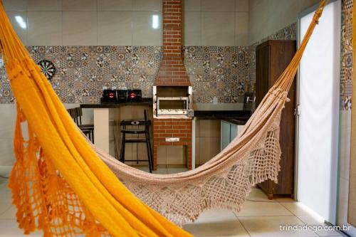 a hammock in a room with a kitchen at Casa com 2 Quartos e Varanda Gourmet in Trindade