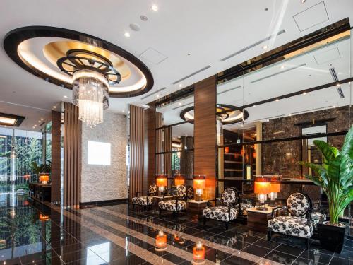 a lobby with chairs and tables and a chandelier at APA Hotel Sugamo Ekimae in Tokyo