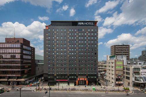 a large building with a sign on the top of it at APA Hotel Sugamo Ekimae in Tokyo