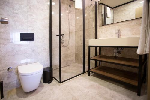 een badkamer met een douche, een toilet en een wastafel bij Beşiktaş Serenity Hotel in Istanbul