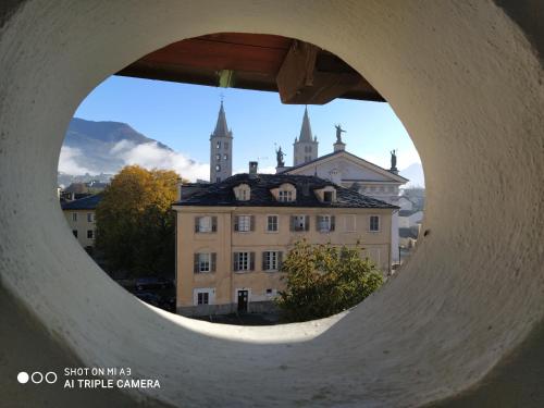 una ventana redonda con vistas a un edificio en Un oeil sur la cathédrale, en Aosta