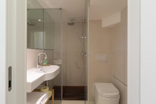 a bathroom with a shower and a sink and a toilet at Quercus Appartements contactless check-in in Patergassen