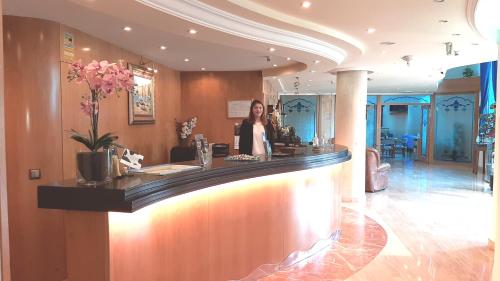 a woman standing at a bar in a restaurant at Hotel Nueva Plaza in Maliaño