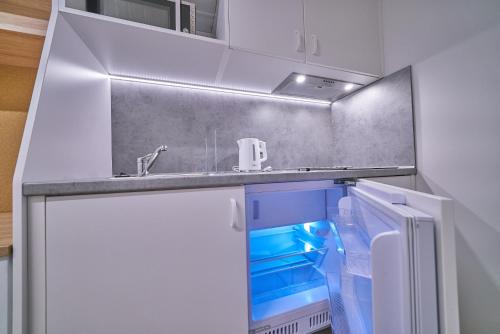 a white refrigerator freezer sitting inside of a kitchen at Apartamenty Collegia in Gdańsk