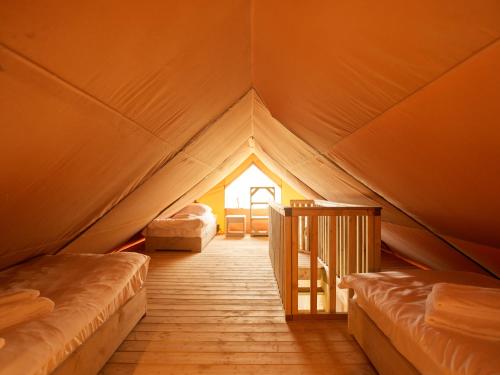 厄伊特海斯特Dutchen Erfgoedpark De Hoop Glamping的帐篷里有两张床的房间